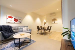 墨尔本Nice View 2br Apt At William St Pool Gym Balcony的带沙发和桌子的客厅