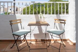 Dos sillas y una mesa en un balcón. en Apartamento los jardines, en Sanlúcar de Barrameda