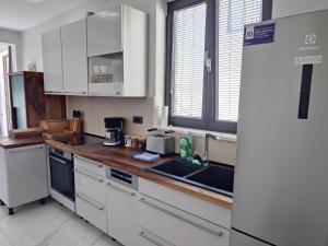 a kitchen with white cabinets and a sink at OCTOPUS in Sutivan