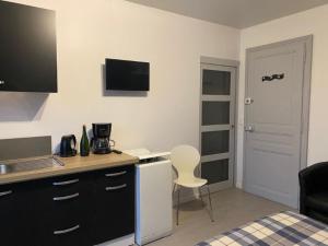 a room with a kitchen with a desk and a chair at Charmant Studio meublé 349 in Vittel