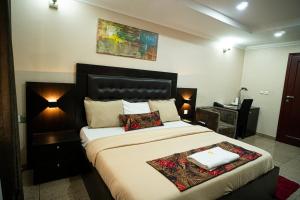a bedroom with a large bed with two pillows at The Lodge-Stack By Kabachi in Lagos