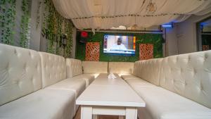a room with white leather seats and a tv at The Lodge-Stack By Kabachi in Lagos