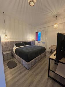 a bedroom with a large bed and a television at Hotel El Jardin in Salento