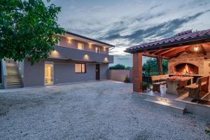 a house with a fireplace and a patio at Holiday house Leone in Bibići