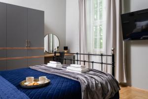 Dormitorio con cama azul y bandeja de comida en Old Town Luxury Apartment - Rynek Szewska, en Cracovia