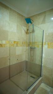a shower with a glass door in a bathroom at The Lodge-Stack By Kabachi in Lagos