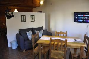a dining room with a table and a couch at La Aljaba in El Bolsón