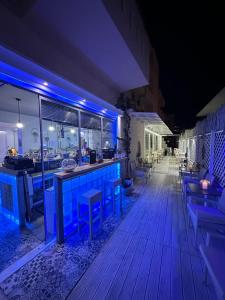 a bar on a deck at night with blue lights at Thalia deco City & Beach Hotel in Hersonissos