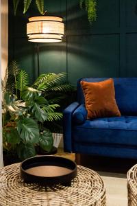 a living room with a blue couch and a table at The Jungle! House with Hot Tub. in Nottingham