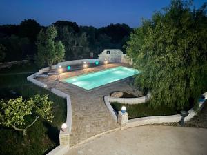 a swimming pool in a backyard at night at Trullo Bubamare in San Michele Salentino