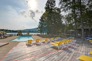 a group of lounge chairs and a swimming pool at Luxurious Scandinavian Cottage with Private Jacuzzi in Lac-Superieur