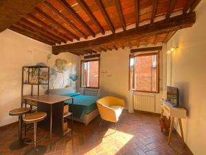 a room with a bed and a desk and chairs at Vannucci 130 in Città della Pieve