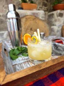 a drink sitting on a wooden table with an orange slice at Assos Sunset Hotel in Behramkale