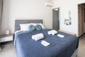 Un dormitorio con una cama azul con toallas. en Villa Pasadra, en Afantou 40 fotos más