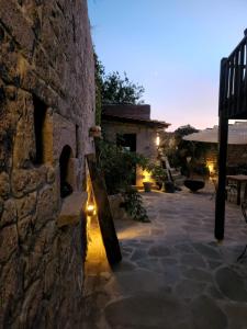 a stone building with a stone wall with lights on it at Assos Sunset Hotel in Behramkale