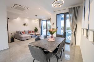 Una sala de estar con una mesa y sillas y un sofá. en Villa Pasadra, en Afantou