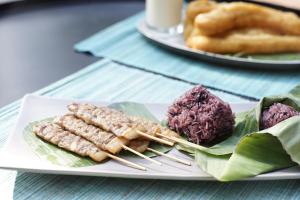 a plate of food on a table with chop sticks at Private Pool Villa 88 Nimman Chiangmai in Chiang Mai
