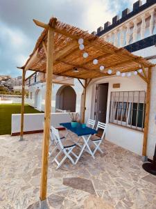 une pergola en bois sur une terrasse avec une table et des chaises dans l'établissement La Juanita - Dosel, à Faro de Cullera