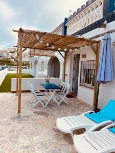 un patio avec une table, des chaises et un parasol dans l'établissement La Juanita - Dosel, à Faro de Cullera