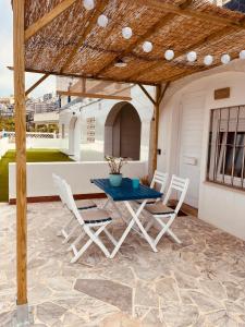 un patio avec une table et des chaises sur un toit dans l'établissement La Juanita - Dosel, à Faro de Cullera