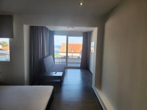 a room with a bed and a chair and a window at Pinecone in Kavala