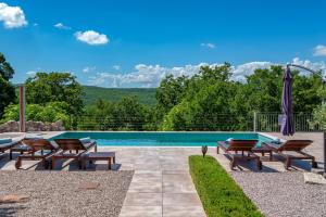 a swimming pool with a group of chairs next to a pool at Villa Veselici in Labin