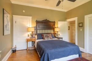 a bedroom with a bed with a wooden headboard and two lamps at Midtown Central Gardens Bungalow in Memphis