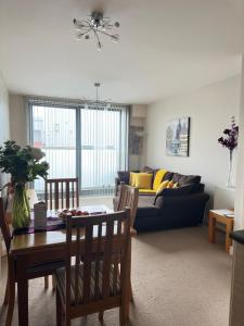 a living room with a table and a couch at Lovely 1 Bedroom Apartment in Plymouth