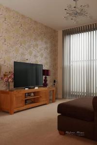 a living room with a flat screen television on a wooden entertainment center at Lovely 1 Bedroom Apartment in Plymouth