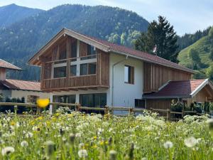 a house in the mountains with a field of flowers at Panorama Chalet in Bayrischzell