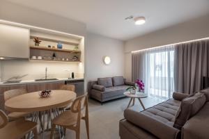 a living room with a couch and a table at Blue Dome Hotel in Platanias +48 photos