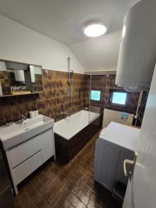 a bathroom with a tub and a sink and a bath tub at Apartment PETRA Mojstrana in Mojstrana +63 photos