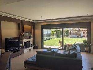 a living room with a couch and a large window at Corinthian Family Home in Isthmia