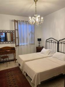 sypialnia z 2 łóżkami i żyrandolem w obiekcie Maison accueillante avec vue sur la mer à Grosseto-Prugna w mieście Grosseto-Prugna