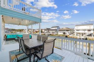 a patio with a table and chairs on a balcony at Kokomo in Myrtle Beach