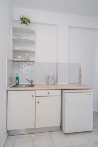 a kitchen with white cabinets and a sink at Fiore Di Mare Studios in Lassi