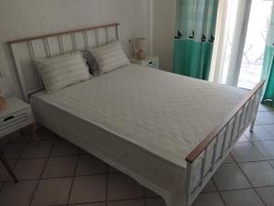 a bedroom with a large bed with a white bedspread at V.K.Seaside Villa in Volos