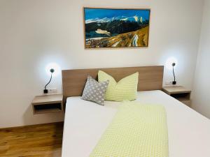 a bedroom with a large white bed with two lamps at Berghoamat Nauders in Nauders +13 photos