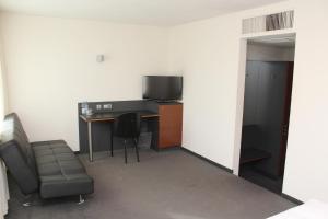 a room with a desk, chair and a refrigerator at Hotel am Hirschgarten in Filderstadt