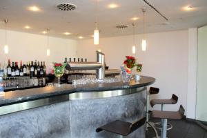 a bar at a restaurant with wine bottles at Hotel am Hirschgarten in Filderstadt