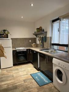 a kitchen with a washer and dryer on the floor at Charmante maison sur propriété in Orly