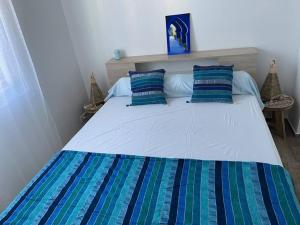 a bedroom with a bed with blue and green pillows at Charmante maison sur propriété in Orly