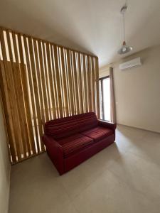 a red couch in a room with a large window at La Corte degli Scolopi in Palma di Montechiaro