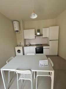 a small kitchen with a white table and chairs at La Corte degli Scolopi in Palma di Montechiaro