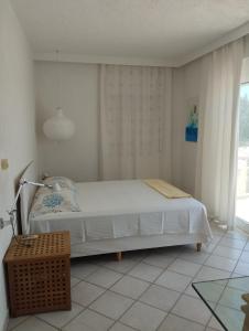 a bedroom with a white bed and a window at V.K.Seaside Villa in Volos