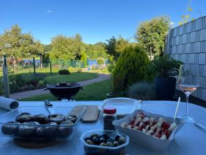 a table with a bunch of food and a glass of wine at Ferienhaus Seekutter mit eigenem Seezugang in Malchow