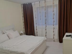 a bedroom with a white bed and a window at Apartament Teo in Iaşi