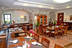 un restaurante con mesas de madera y sillas de madera en Hotel & Restaurant Braunstein - Pauli´s Stuben, en Purbach am Neusiedlersee