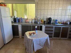 een keuken met een tafel met een fles water erop bij Pousada da Dindinha Cacia in Monte Alegre de Minas