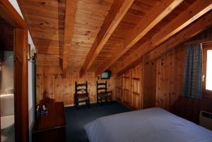 una camera da letto con un letto e due sedie di Hôtel Garni Les Bouquetins a Zinal